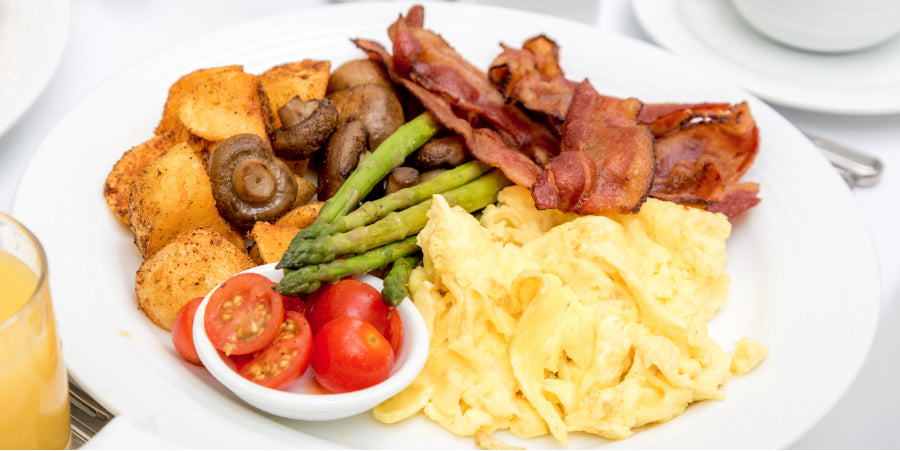 Powdered eggs cooked on a plate with bacon and potatoes