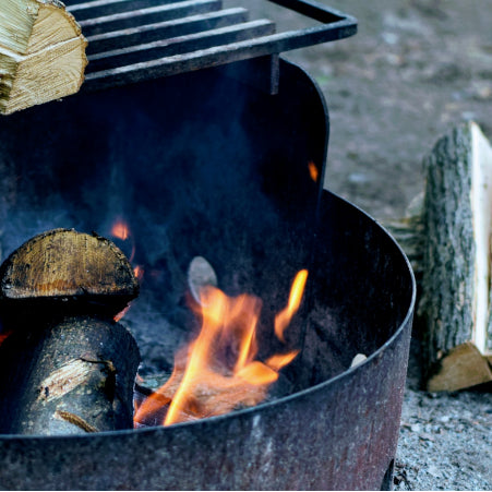 campfire in fire pit with grill for cooking