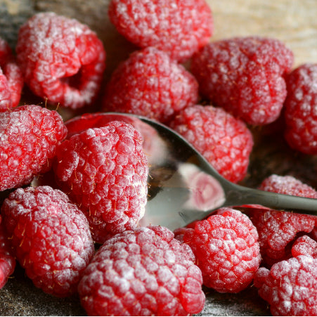 raspberries and powdered sugar on cutting board