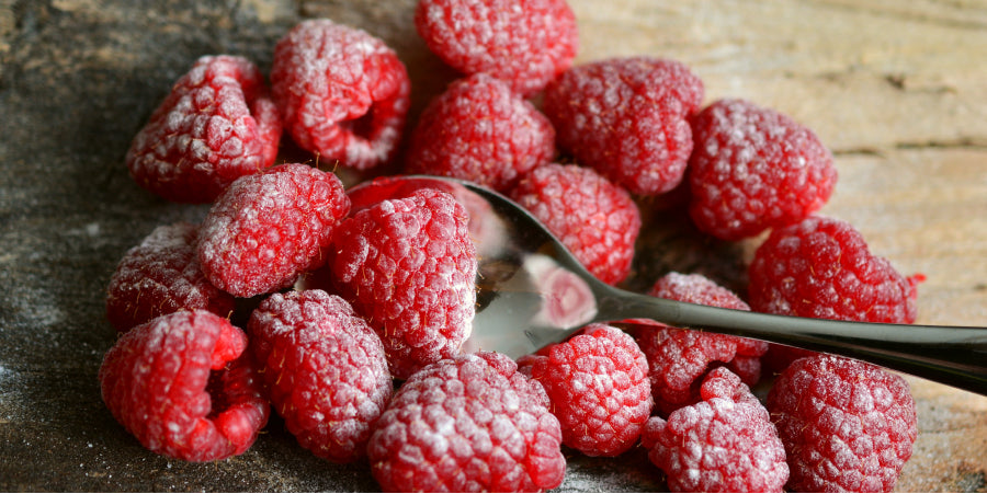 raspberries and powdered sugar on cutting board