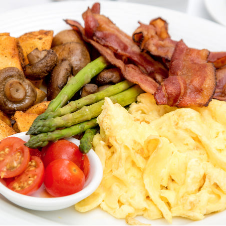 Powdered eggs cooked on a plate with bacon and potatoes